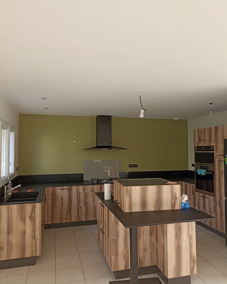 Peinture murale cuisine – mur vert olive derrière le plan de travail – Ramboz Le Peintre – Cholet